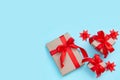 Three gift boxes with a red bow and origami paper stars on a pastel blue background. Minimal festive composition. Copy space for Royalty Free Stock Photo