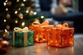 three gift boxes sitting on a table near a christmas tree