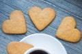 three gingerbread heart shaped biscuits near border of white porcelain coffee cup. Coffee break with love. Homemade Royalty Free Stock Photo