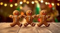 Three gingerbread man dancing on the wooden kitchen table with colorful bokeh in the background