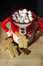 Three gingerbread cookies in a hot chocolate Mrs. Clause cute mug with marshmallows Royalty Free Stock Photo