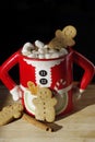 Three gingerbread cookies in a hot chocolate cute Mrs. Clause mug with marshmallows Royalty Free Stock Photo