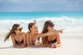 Three girls in bikini sunbathing lying on the sand Royalty Free Stock Photo