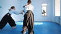 Three girls in black hakama practice Aikido