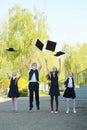 Three girls and a boy are elementary school graduates in a graduate hat Royalty Free Stock Photo