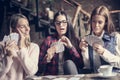 Three girls in cafe playing game cards.