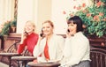 Three girls in cafe speaking on phone. conference call. business meeting at lunch. people connection. modern society Royalty Free Stock Photo