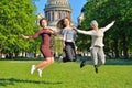 Three girls coeds have fun jumping on the background of St. Isaa