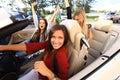 Three girls driving in a convertible car and having fun. Royalty Free Stock Photo