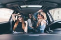 Three girls driving in a convertible car and having fun, listen music and dance Royalty Free Stock Photo