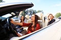 Three girls driving in a convertible car and having fun. Royalty Free Stock Photo