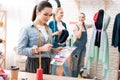 Three girls at garment factory. They are choosing colors for new dress on pattern. Royalty Free Stock Photo