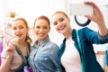 Three girls at garment factory. They are taking selfie desining new dress. Royalty Free Stock Photo