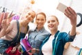 Three girls at garment factory. They are taking selfie desining new dress. Royalty Free Stock Photo