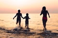 Three girls having fun at sunset beach - friendship freedom beach summer holiday concept Royalty Free Stock Photo