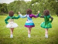 Three girls in irish dance dress and wig posing outdoor