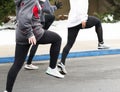 Three girls performing track warm up drills in parking lot