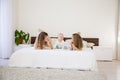 Three girls play sisters in the morning on the bed in the bedroom Royalty Free Stock Photo