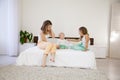 Three girls play sisters in the morning on the bed in the bedroom Royalty Free Stock Photo