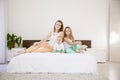 Three girls play sisters in the morning on the bed in the bedroom Royalty Free Stock Photo