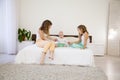 Three girls play sisters in the morning in the bedroom on the bed Royalty Free Stock Photo