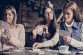 Three girls playing card in cafe. Royalty Free Stock Photo