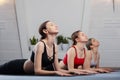 Three girls practicing yoga. Yoga instructor with her students meditating in a studio Royalty Free Stock Photo