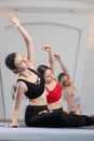 Three girls practicing yoga. Yoga instructor with her students meditating in a studio Royalty Free Stock Photo