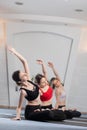 Three girls practicing yoga. Yoga instructor with her students meditating in a studio