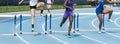 Three girls racing the 400 meter hurdles Royalty Free Stock Photo
