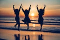 Three girls silhouette jumping on the beach with the sunset in the background. Royalty Free Stock Photo