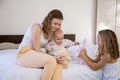 Three little girls sisters play in the bedroom on the bed in the morning Royalty Free Stock Photo