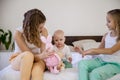 Three little girls sisters play in the bedroom on the bed in the morning Royalty Free Stock Photo