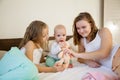 Three little girls sisters play in the bedroom on the bed in the morning Royalty Free Stock Photo