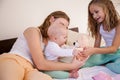 Three little girls sisters play in the bedroom on the bed in the morning Royalty Free Stock Photo