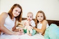 Three girls sisters in the play in the bedroom in the morning love Royalty Free Stock Photo