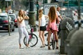 Three girls on the street with city bikes