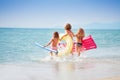 Three girls with swimming tools running to the sea Royalty Free Stock Photo