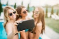 Three girls in swimsuits ad sunglasses make selfie Royalty Free Stock Photo