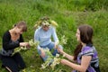 Three girls is twist flowers into a wreath Royalty Free Stock Photo