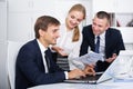 Three glad business workers holding documents