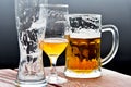 Three glass beer mugs on the table - empty, full, half full Royalty Free Stock Photo