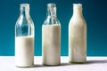 Three glass bottles with dairy product on a blue background.