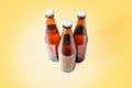 Three glass with bottles of dark beer on a yellow background. Top view. Copy space. Alcoholic beverages and drinkings Royalty Free Stock Photo