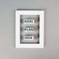 Three glass bottles with the words idea, plan and goal in a frame, education, marketing and business concept, brainstorming