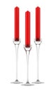 Three glass candlesticks with red candles isolated