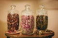 Three glass containers full of different sort of dried tea leaves with different colours