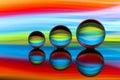 Three glass crystal balls in a row with a rainbow of colorful light painting behind them Royalty Free Stock Photo