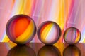 Three glass crystal balls in a row with a rainbow of colorful light painting behind them Royalty Free Stock Photo