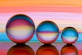 Three glass crystal balls in a row with a rainbow of colorful light painting behind them Royalty Free Stock Photo